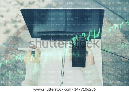 Growth and trade concept with woman using cell phone and notebook and business chart screen with going up green graphs. Double exposure