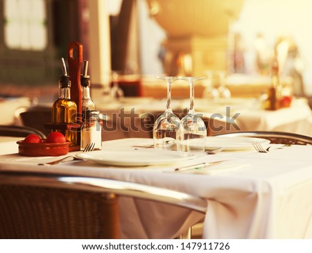 Empty outdoor restaurant table at sunset Royalty-Free Stock Photo #147911726
