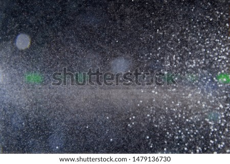 Abstract white blurred dust explosion and flash with illumination on a black background