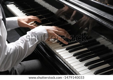 Man playing grand piano at the concert, closeup