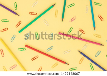 Education or back to school concept. Top view of colorful clip, pen on yellow background. Flat lay