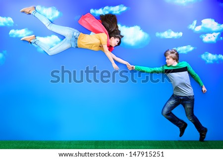 Couple of young people in love flying in the sky.