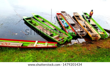 Old wooden sampan at river side in the morning scenery.