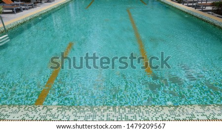 An empty swimming pool with clear water and green floor Background 