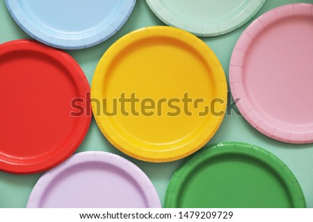Colorful paper plates on light background.
