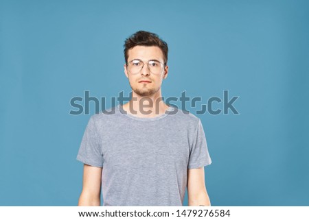 Cute emotional man gray t-shirt lifestyle glasses blue background