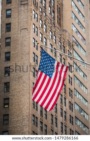 American flag with office building at the background. Manhattan buildings of New York City center - Wall street