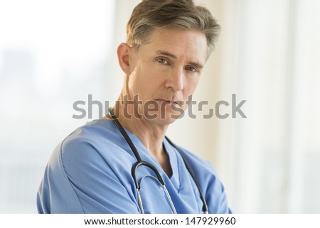 Portrait of confident mature male surgeon in hospital