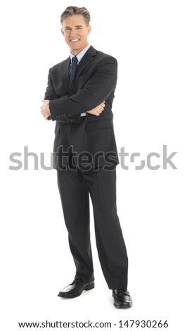 Full length portrait of confident mature businessman standing arms crossed isolated over white background