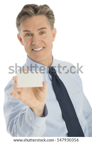 Portrait of happy mature businessman displaying blank business card against white background