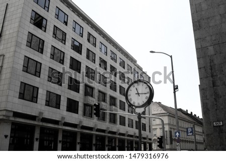 Street clock on a building background, black-and-white photo