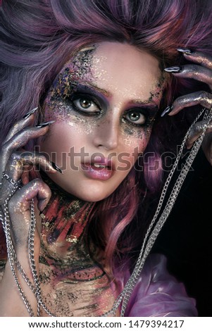close up  portrait of young beautiful girl with colorful face painting. Halloween professional makeup. hair in paint. beauty portrait. pink and purple hair. chain in hands