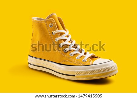 Yellow sneakers on yellow background with copy space. Youth shoes. Royalty-Free Stock Photo #1479415505