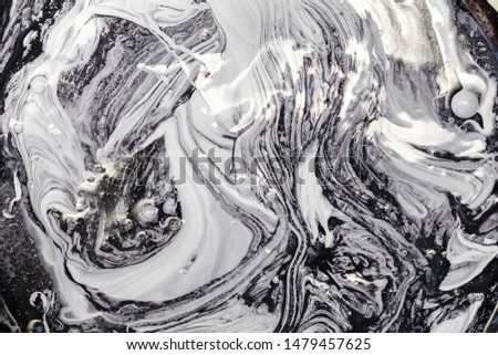 Mixing white and black paint, abstract pattern effect.