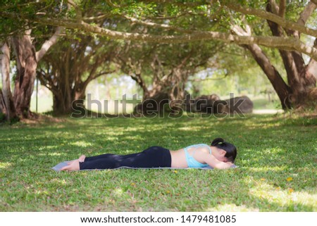 Young woman practicing yoga healthy lifestyle in the public park. Concept of relaxation for green nature.