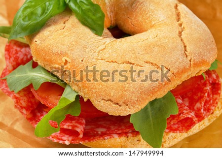 Friselle sandwich with italian salami, tomato and herbs