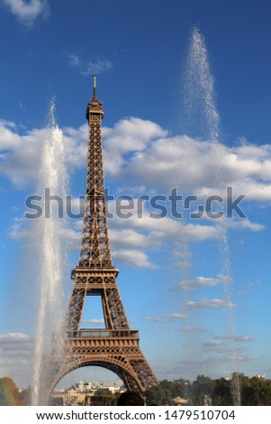 water of Fountain and the Big Eiffel Tower on the blue sky with clouds