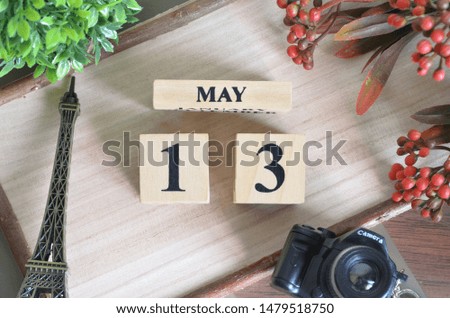 May 13. Date of May month. Number Cube with a flower camera and Sign wood on Diamond wood table for the background.