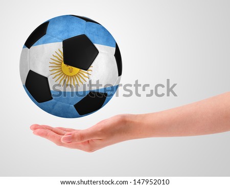 Hands holding a ball with flag of argentina