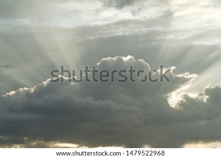 Rainy cloud with rays of sunset