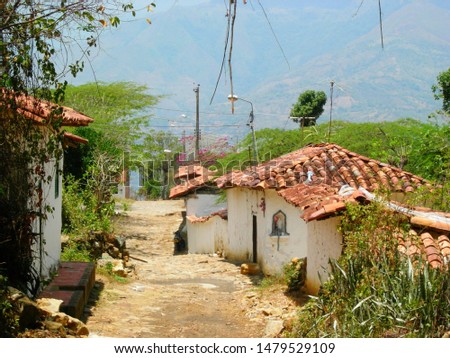 Small stone street with white houses and orange roofs in the small town of Guane, Colombia 