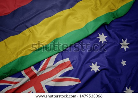 waving colorful flag of australia and national flag of mauritius. macro