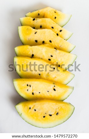 cut a slices of ripe yellow melon on a white background