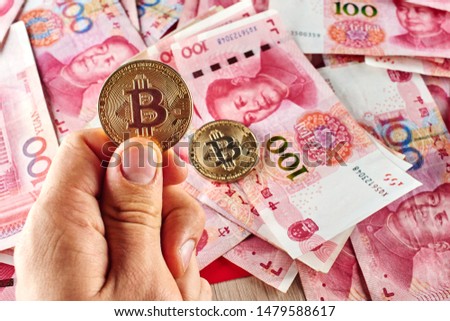 Chinese Yuan money and cryptocurrency Bitcoin close-up. Digital virtual internet currency investment concept