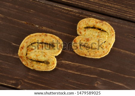 Group of two whole savory cheese palmier flatlay on brown wood