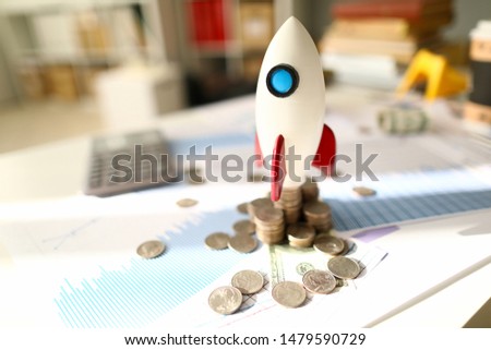 White space rocket make business startup against money and chart background. Financial education concept