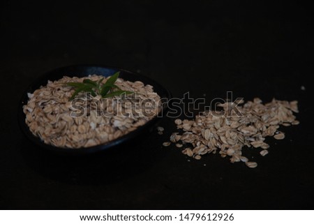 oatmeal or oat flakes in a bowl on a dark stone
