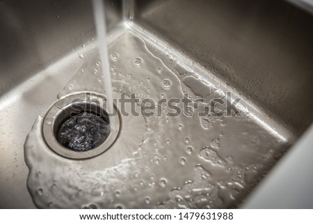 Stainless kitchen sink with food waste disposal in modern home Royalty-Free Stock Photo #1479631988