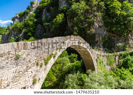 Bridge of Kokkoros or Noutsos in Epirus mountain greek region. One-arch stone bridge situated on the river of Voidomatis in the municipality of Central Zagori. Zagorohoria, Greece. Royalty-Free Stock Photo #1479635210