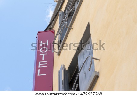 red and white letters sign hotel in building street in France south