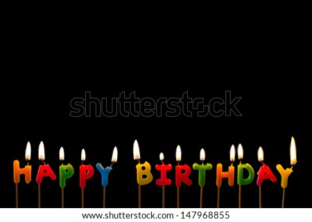 Colorful happy birthday candles on black background