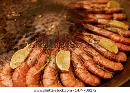 Large prawns in an iron plate with lemon.