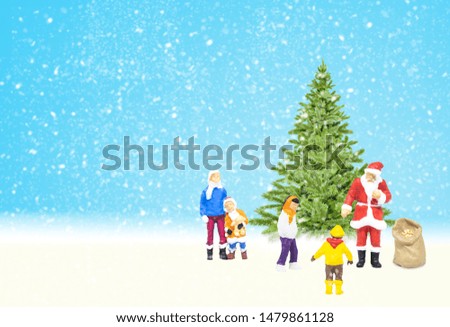 Merry Christmas and Happy New Year Concept : Red Santa Claus giving Christmas gift to group of children or kids with pine trees and snowfall in the background.
