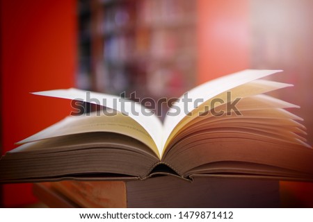Academic book was opened on top of other book in study room. Selective focused picture background of library. Educational, vocational, or school concept image of books on a table in self learning room