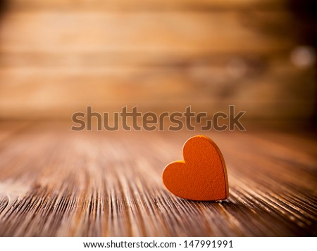 Stone heart on a wooden background.