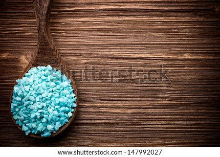 Spa stones in the wooden spoon, wood background.