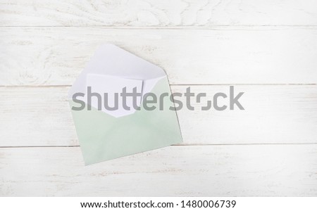 envelope and blank card on white wooden table. Party Invitation Mockup. Styled Photography Template. Flat lay, copy space