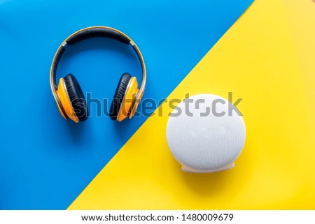Audio listening with wireless headphones and portable speakers on yellow and blue background top view
