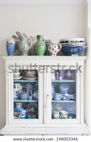 Crockery displayed in storage cabinet at home Royalty-Free Stock Photo #148003346