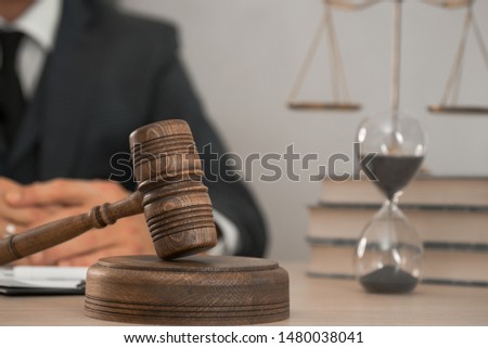 Law and Legal services concept. Male lawyer or judge working with contract papers, Law books and wooden gavel on table in courtroom 