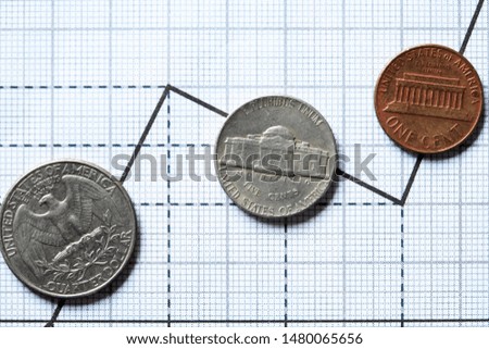 Closeup of few USA coins on paper background with graph