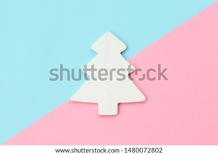 White Christmas tree on pink and light blue background. New Year, Christmas and winter concept. Flat lay, top view.