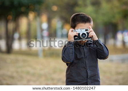 Little Boy With Retro Camera In Autumn Park
