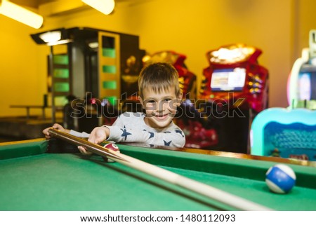 A little boy playing billiards. Sport is life