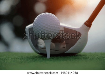 Golf ball and golf club in beautiful golf course at sunset background.