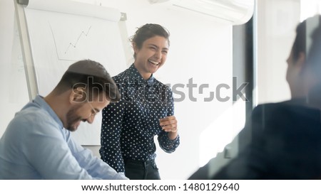 Office workers take break having fun joking laughing at business briefing lead by indian businesswoman in boardroom view through glass door. Clients and ceo meeting or team building activities concept Royalty-Free Stock Photo #1480129640